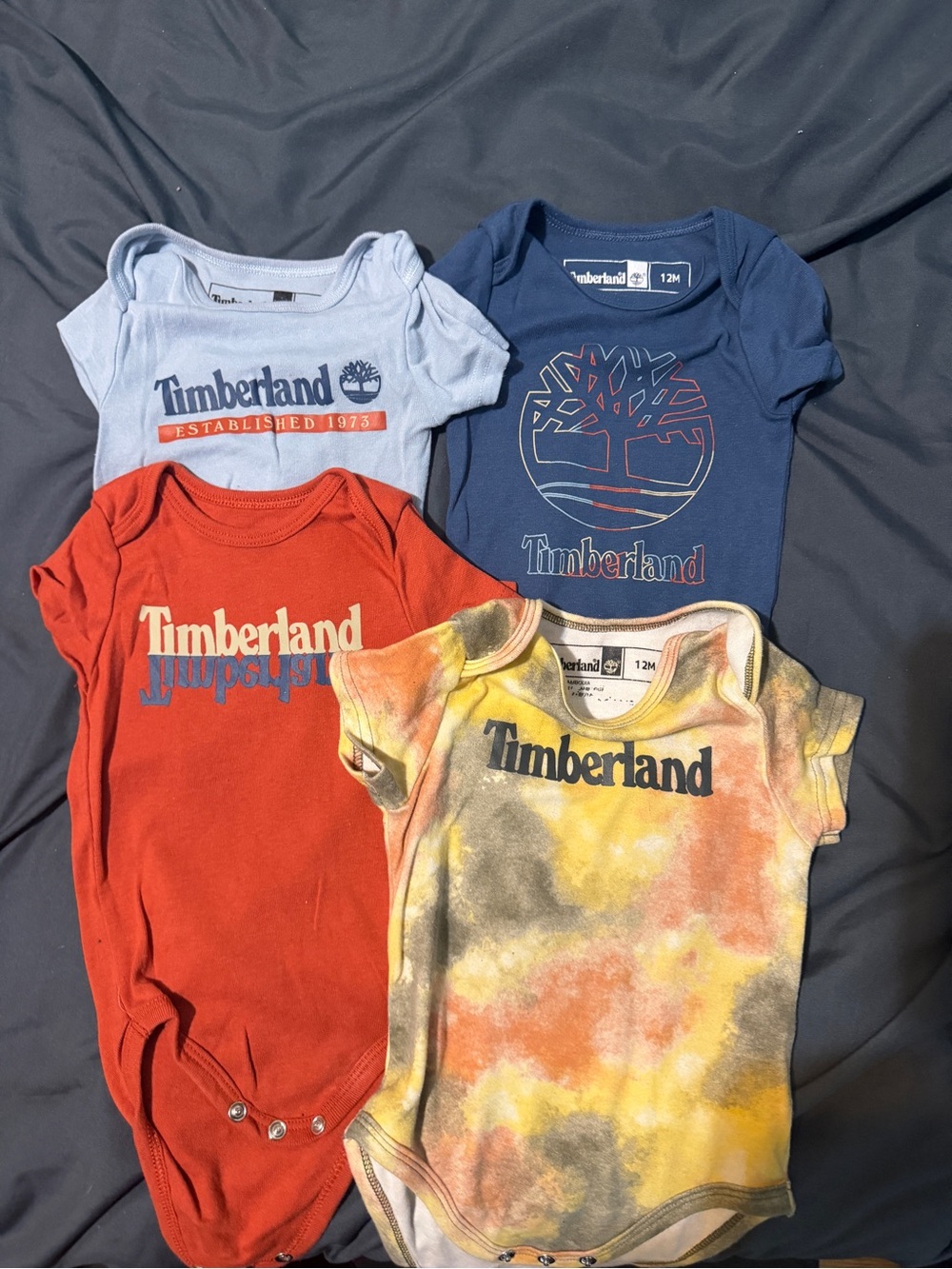 4 Timberland Baby Onesie Bundle - Blue, Light Blue, Red, Yellow Tie-Dye